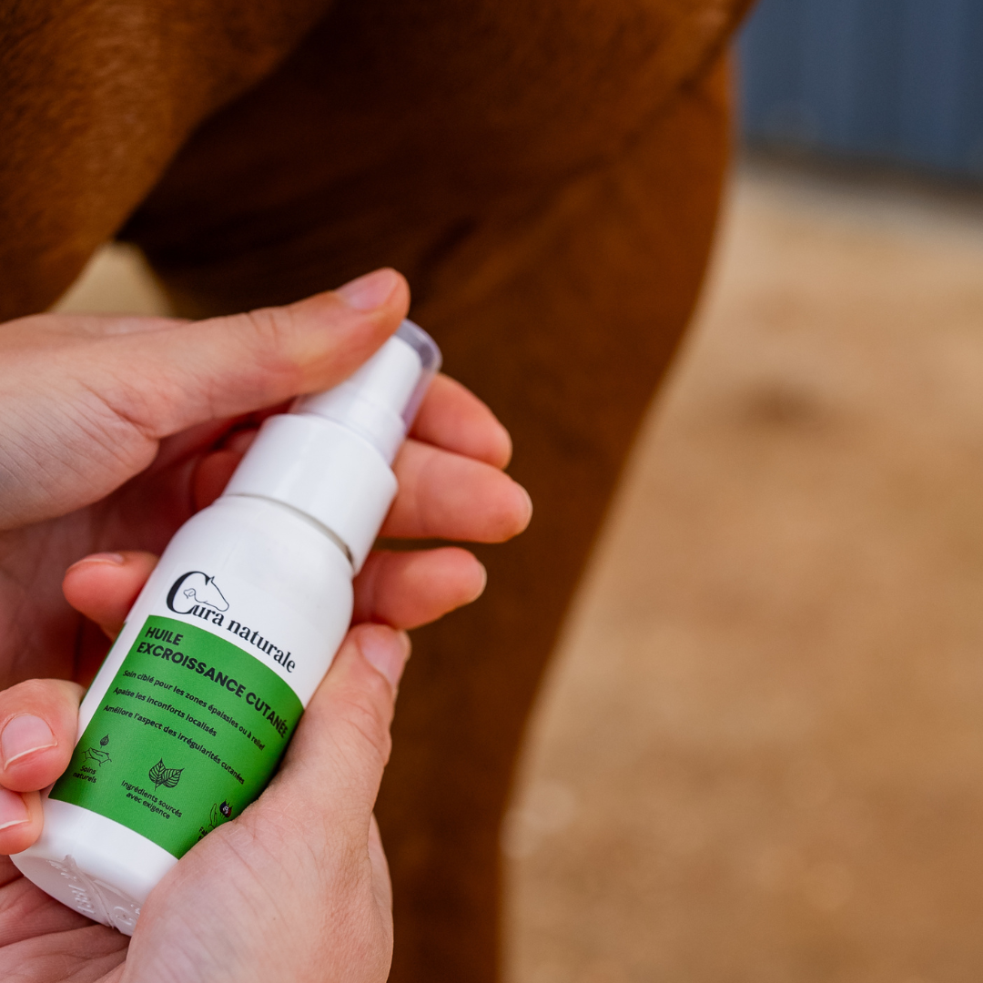 Huile excroissance cutanée cheval - flacon spray en main - Cura naturale